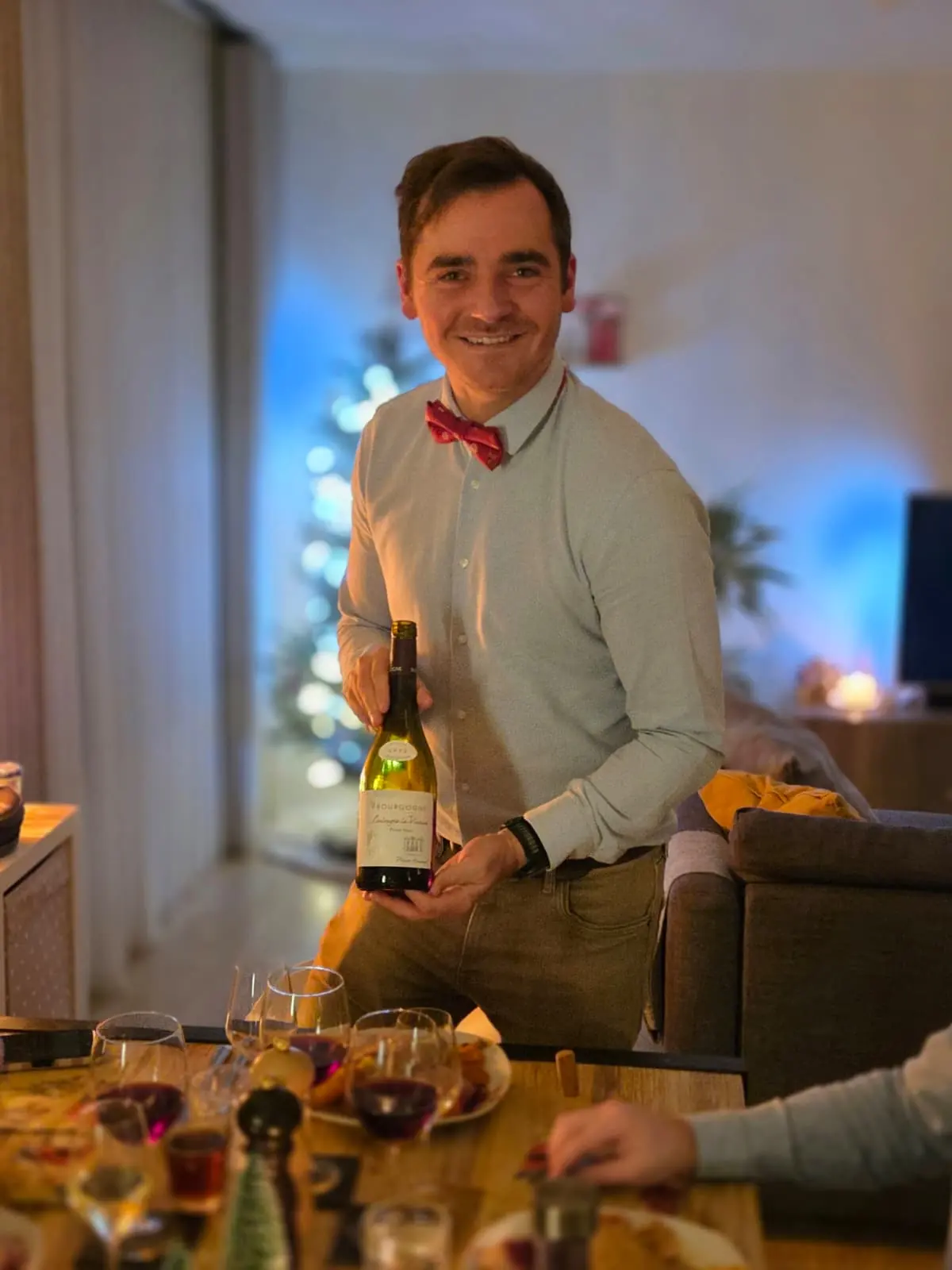 Kasper stelt een fles Bourgogne voor aan een gedekte tafel